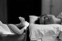 A mother looks at her newborn baby's feet