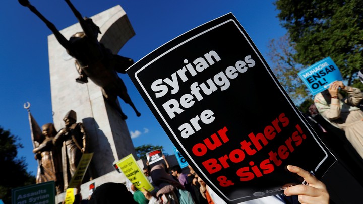 Demonstrators hold placards in support of Syrian refugees during a protest in Istanbul.