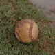 A baseball in a muddy field