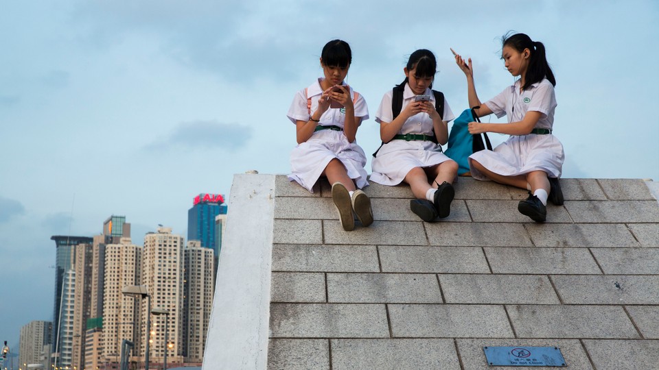 Photograph of young girls in China using their smartphones