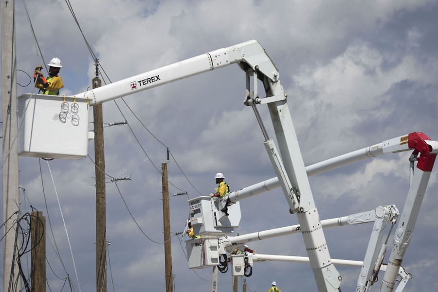 Power crew members in at least four lift buckets work on downed lines.