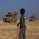 Turkish armored vehicles conduct a joint ground patrol with American forces in the "safe zone" on the Syrian side of the border with Turkey
