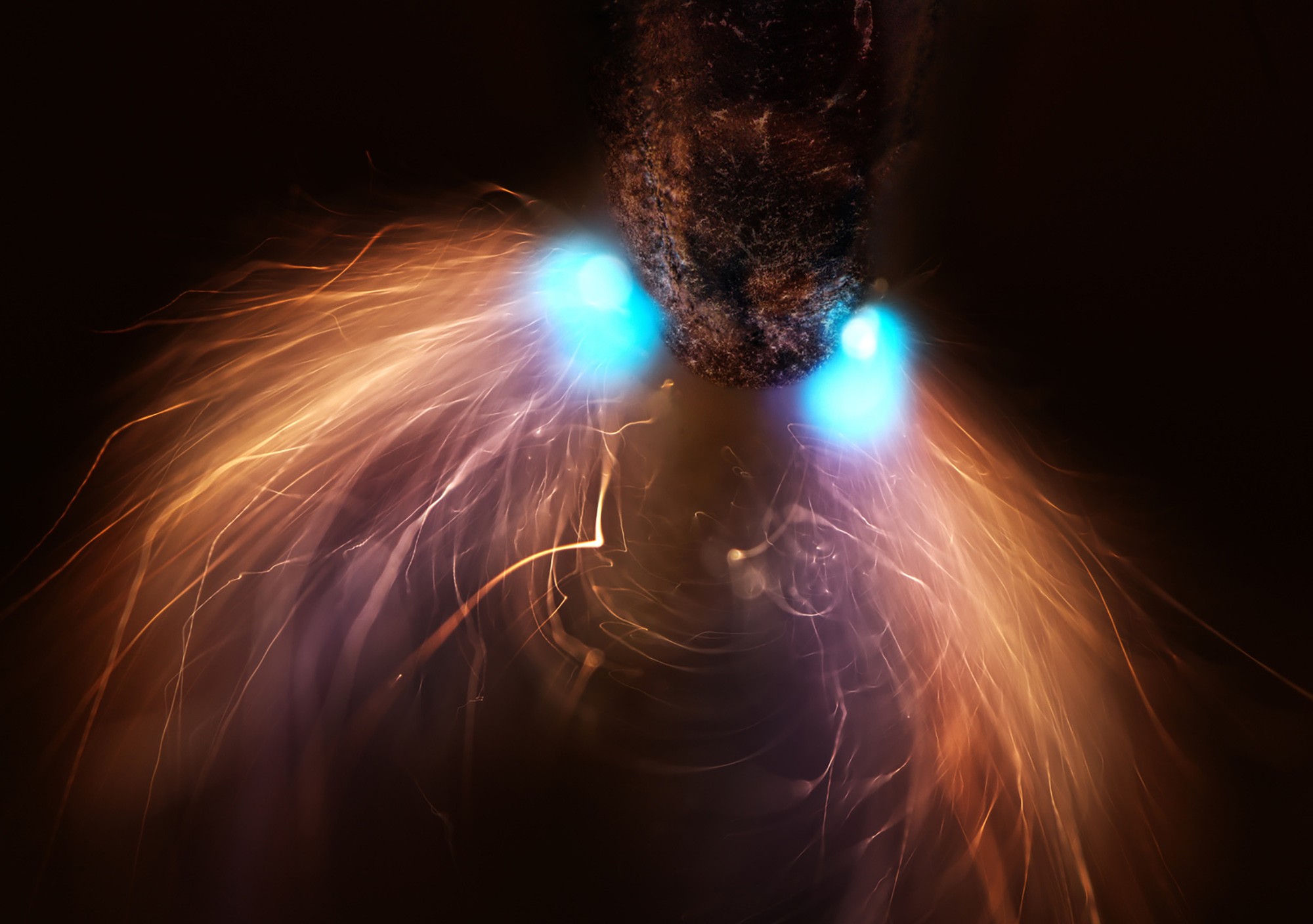 A very close view of the tip of a pencil being struck and illuminated by sparks