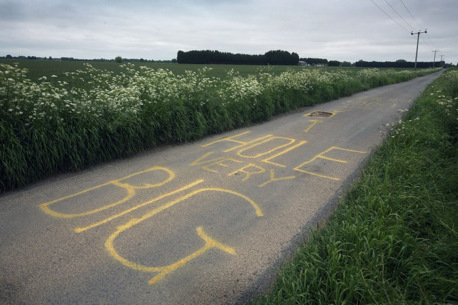 A huge pothole in a lane has been marked with a large warning message in yellow paint, which reads "Hole Very Big."