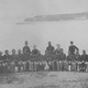 Black Civil War soldiers sitting in a row in front of standing white officers