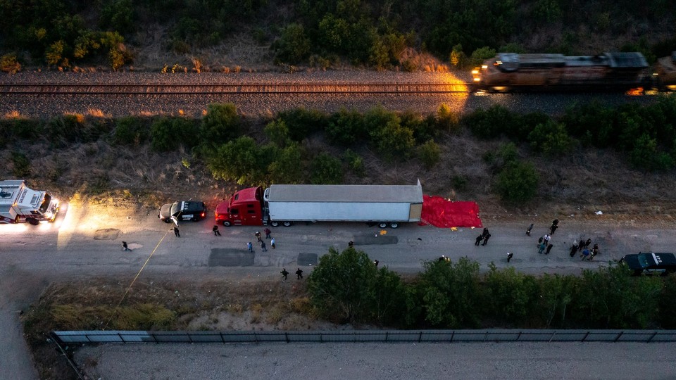 Members of law enforcement investigate the tractor trailer in San Antonio, Texas