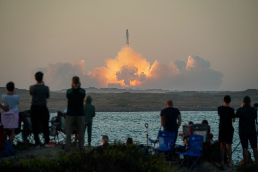 People watch a distant rocket launch.