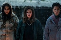 Three girls in the TV show "Yellowjackets" standing in the cold