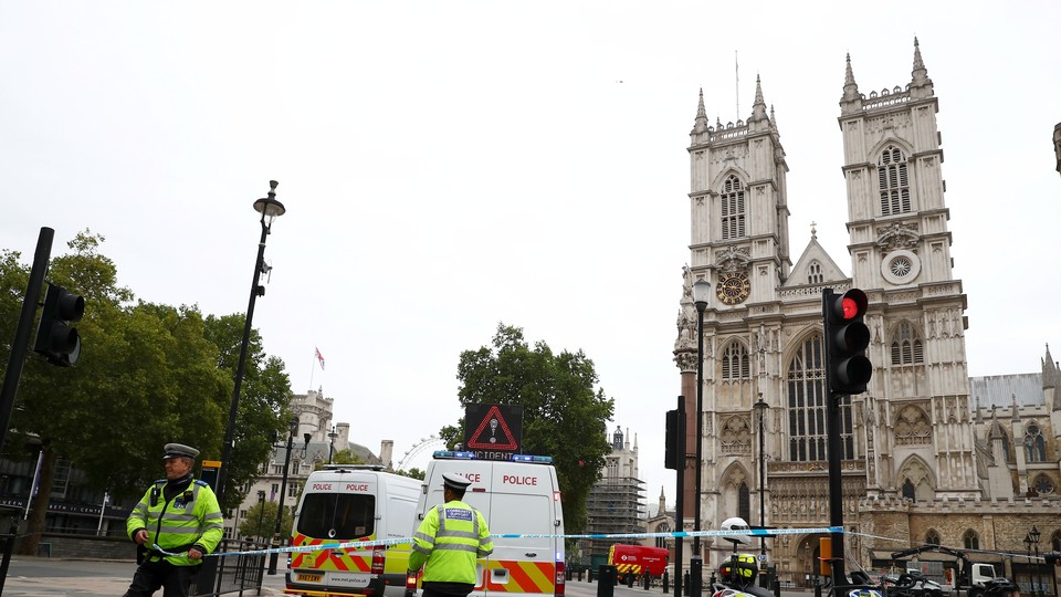 Police officers stand at a cordon after a car crashed outside the Houses of Parliament in Westminster on August 14, 2018.