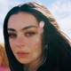 Charli XCX stares at the camera in "Beg for You"