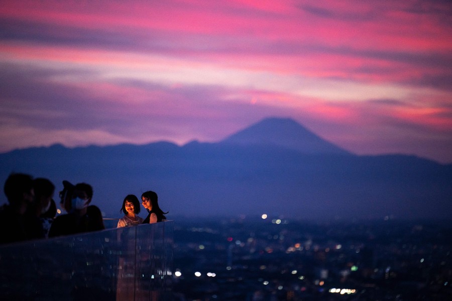 People enjoy an observation deck at sunset.