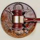 A gavel hitting the wooden seal of the United States