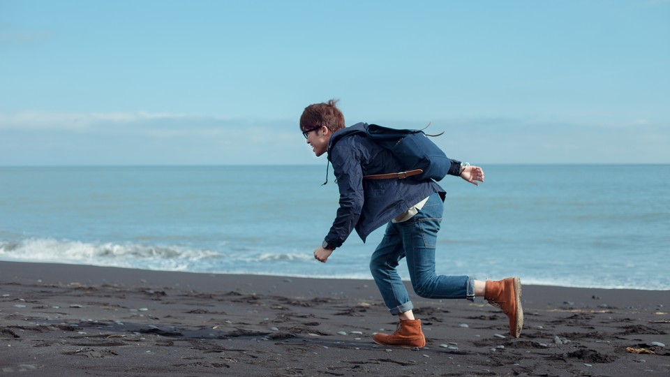 A man running in jeans on the beach