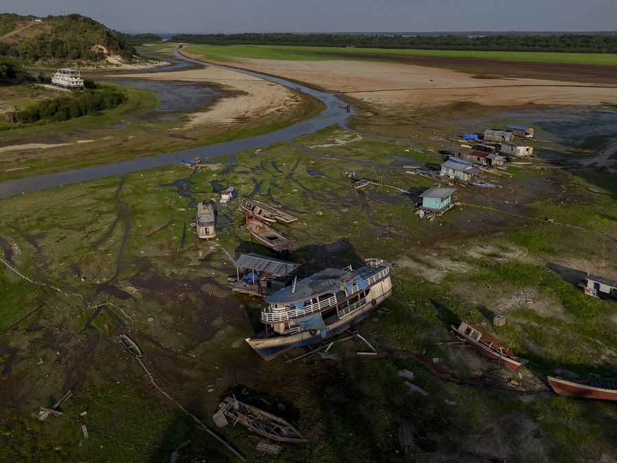 Boats and houses are seen stranded in a dried-up lake.