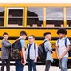 Photo of a group of middle schoolers in front of a yellow bus