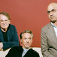 photo of Robert Downey Jr. sitting, flanked by Bartlett Sher in glasses and blue-green blazer on left and Ayad Akhtar in glasses and tan blazer on right