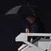 President Trump carrying a black umbrella as he disembarks Air Force One