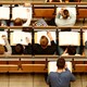 An overhead shot of students with open notebooks on desks in a lecture hall