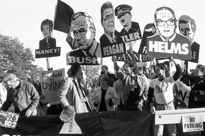 Members of the AIDS activist group ACT UP hold signs of George W. Bush, Ronald Reagan, Nancy Reagan, and Jesse Helms with the word "Guilty" stamped on their foreheads at a protest at the FDA headquarters, in Rockville, Maryland.
