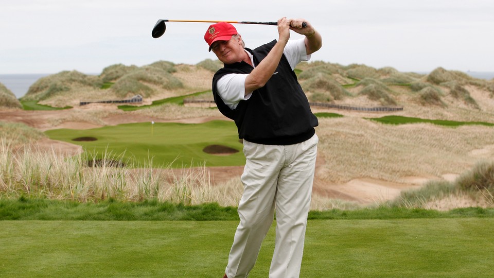 Donald Trump swings a club on a golf course in Scotland.