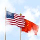 The U.S. and Chinese flags fly amid clouds.