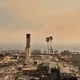 Color photo of debris from a house completely destroyed by wildfire except its fireplace chimney.