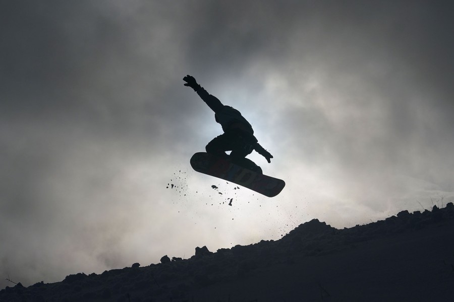 A person jumps while snowboarding.