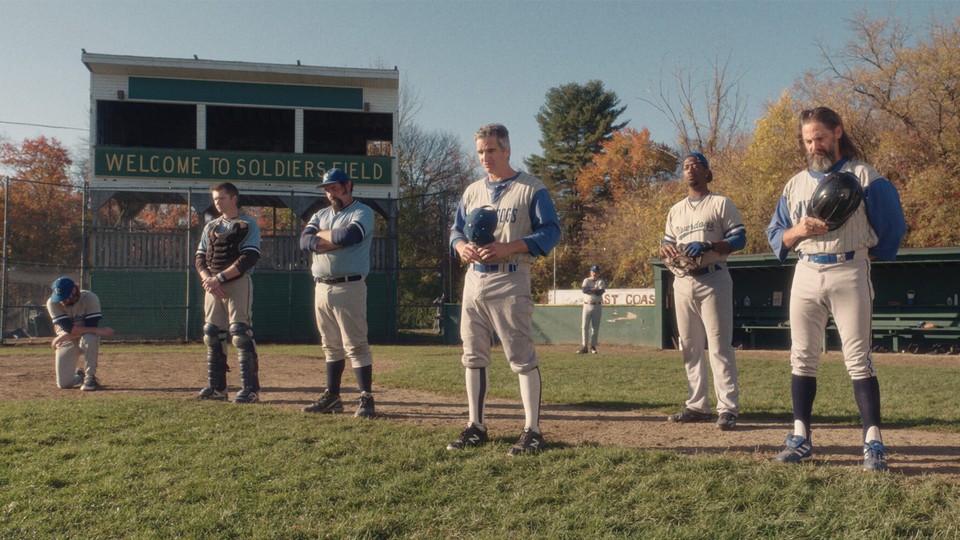 Baseball players stand in a field
