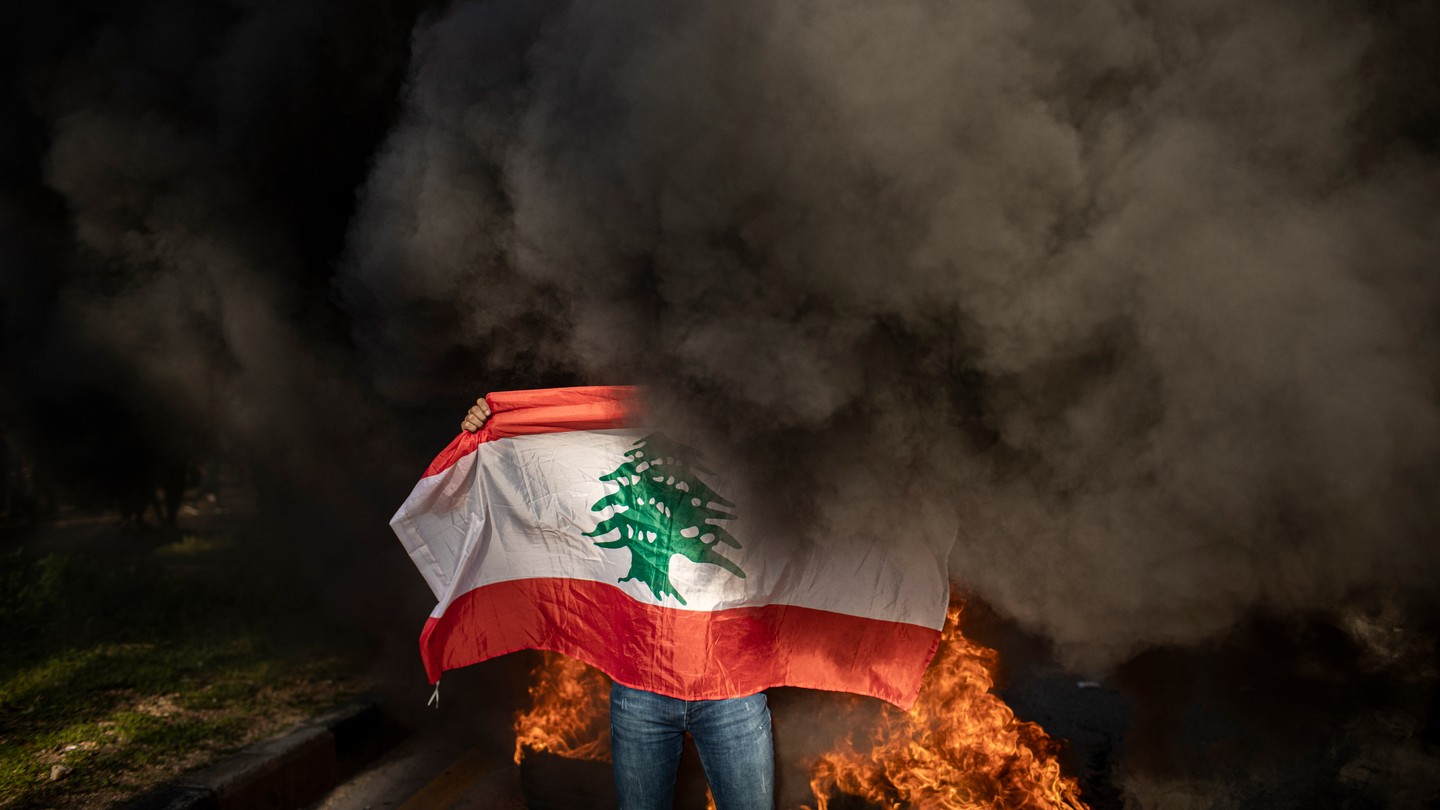 A protester holds up the Lebanese flag on the streets of Beirut.