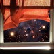 An illustration of a window looking out at a simulated Webb view of the cosmos