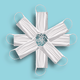 White surgical masks arranged in the shape of a snowflake