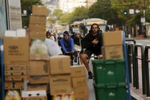 A bike lane is blocked by packages being unloaded.