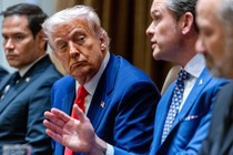 A photo of Pete Hegseth talking as Donald Trump looks on