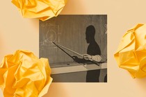 A black-and-white photo of a male teacher using a stick to point at a mathematical drawing on a chalkboard