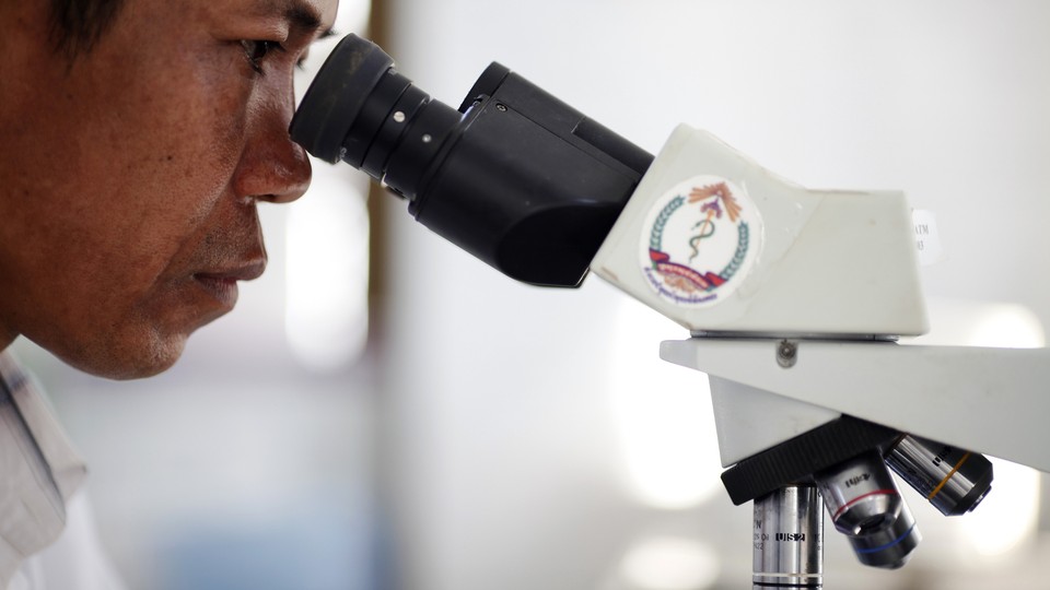 A Cambodian technician uses a normal microscope.