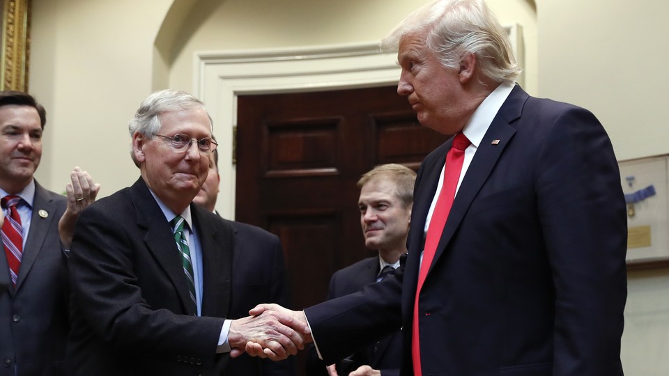 Mitch McConnell and President Trump shake hands.