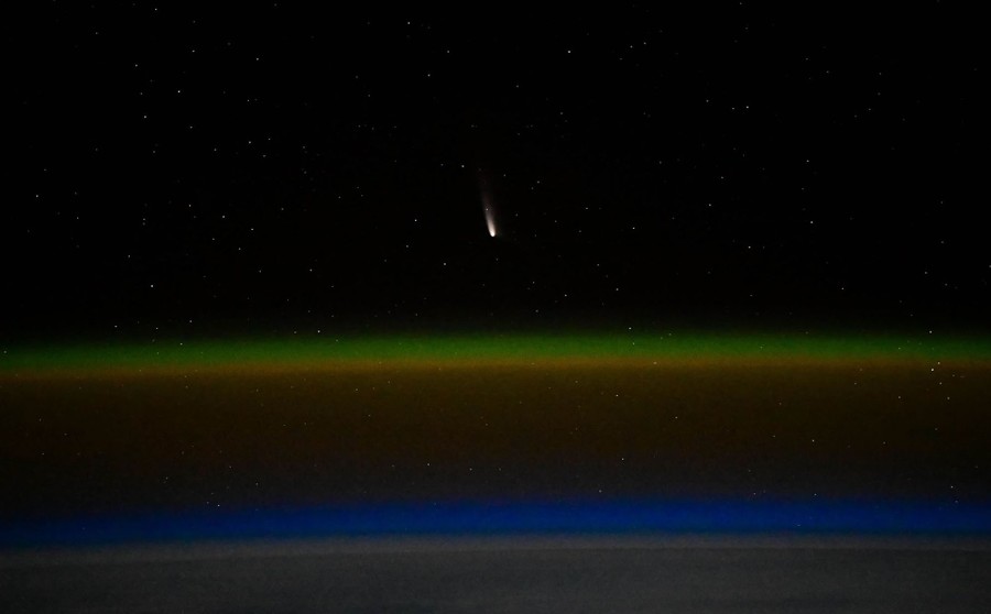 A view of a distant comet, seen above the curve of the Earth's surface and layers of atmosphere