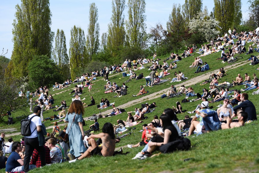 People sit in a park, enjoying a sunny day.