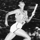 a woman running across the finish line in a track relay race