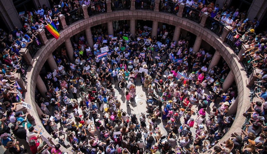 A large crowd of protesters inside a circular room beneath a capitol building dome