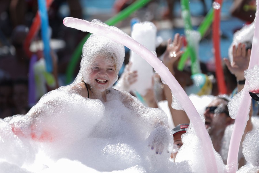People play in foam bubbles.