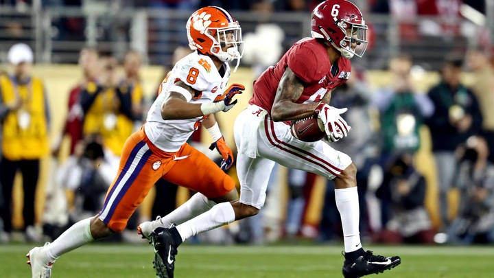 Two college football players mid-game