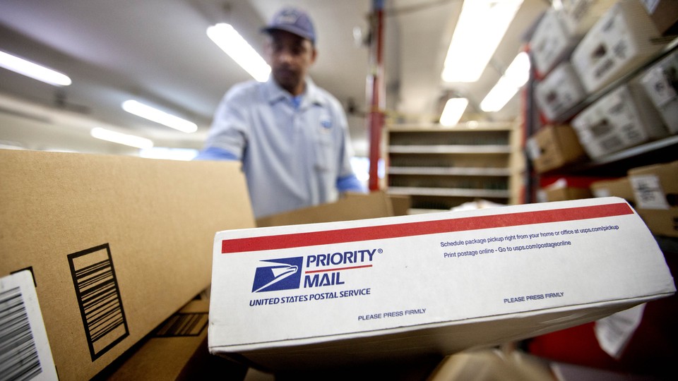 A mailman carrying several USPS packages