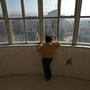 A child with autism looks out a window at the Xining Orphan and Disabled Children Welfare Center, in China.