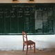 A chair sits at the bottom of a blackboard with election tallies written on it.