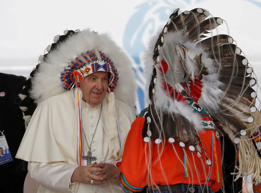 Pope Francis wears an Indigenous headdress at a meeting in Canada.