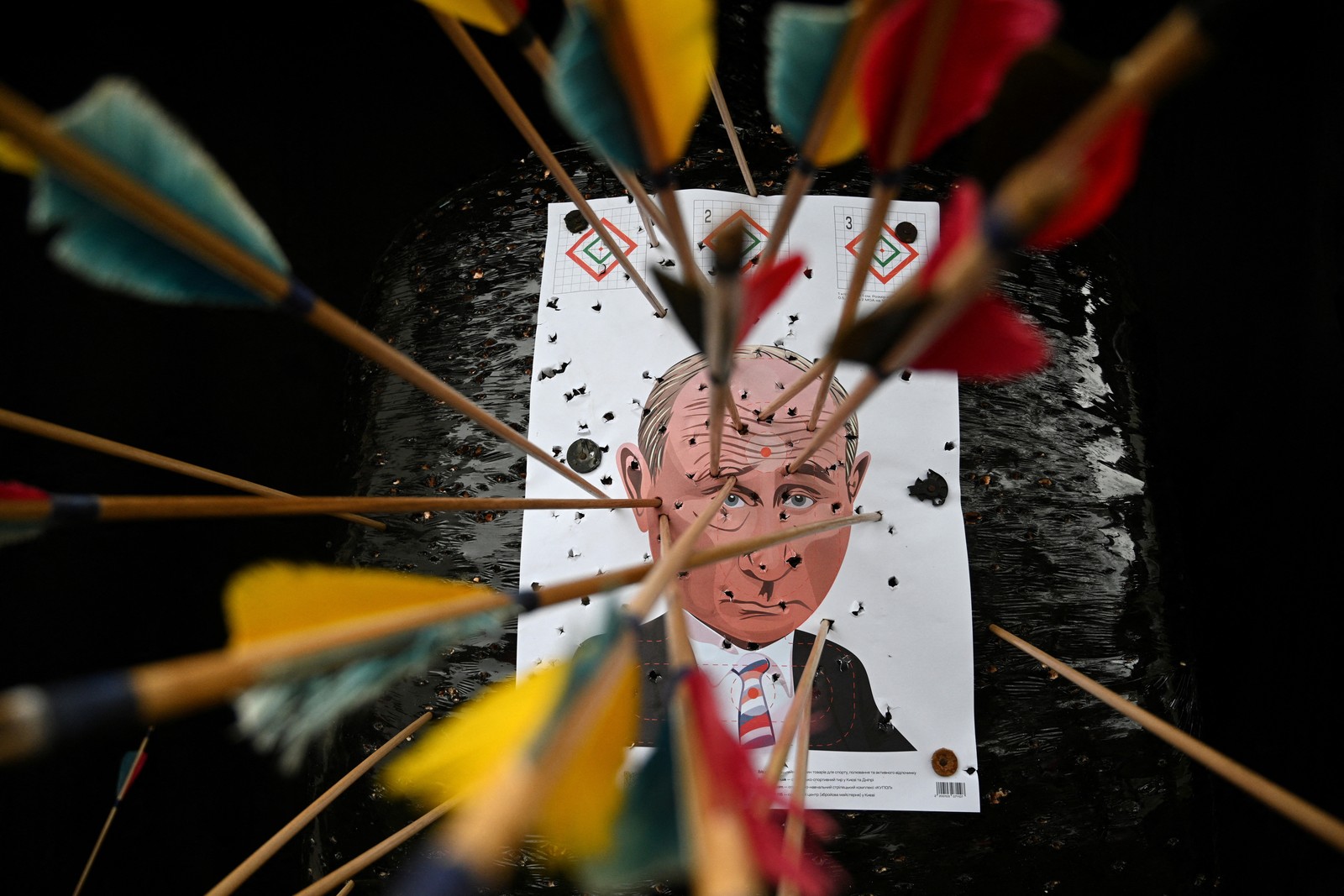 An archery target featuring a drawing of Russian president Vladimir Putin, pierced by many arrows