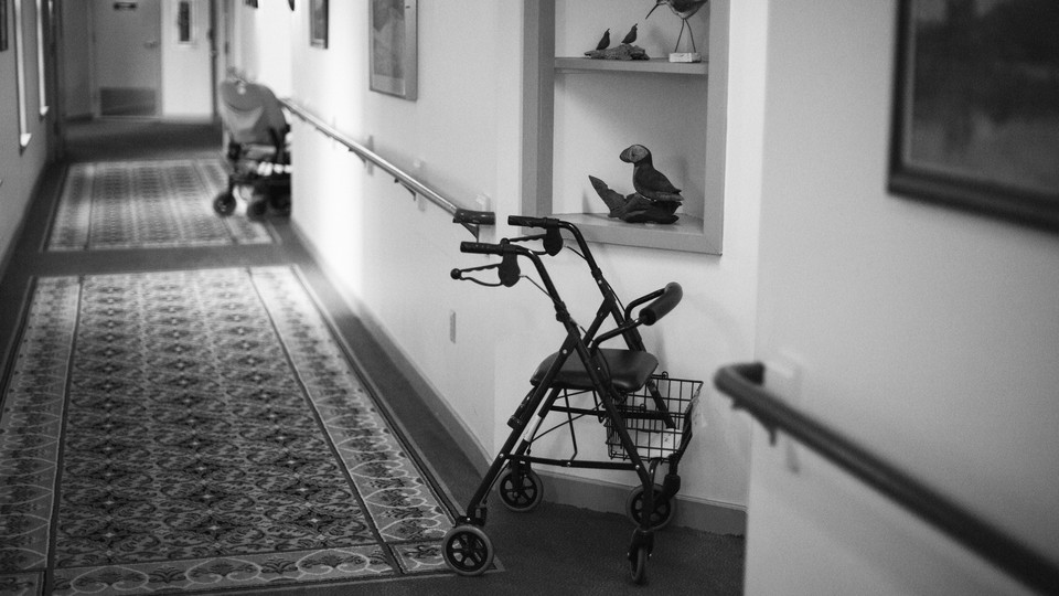 A walker sits in the hallway of an assisted-living facility.
