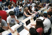 Students sit with Mac laptop computers