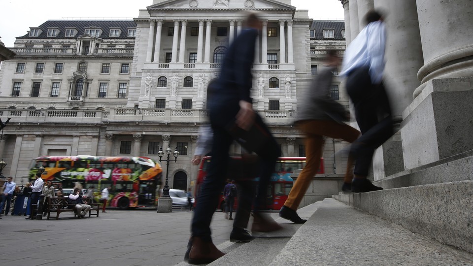Pedestrians walk past the Bank of England